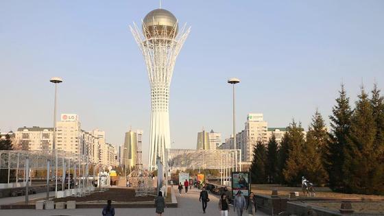 Люди гуляют в районе монумента "Байтерек" Люди гуляют в районе монумента "Байтерек"