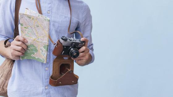 Турист с картой и фотоаппаратом Турист с картой и фотоаппаратом