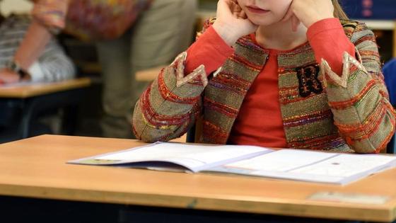 Девочка сидит за партой в школе Девочка сидит за партой в школе