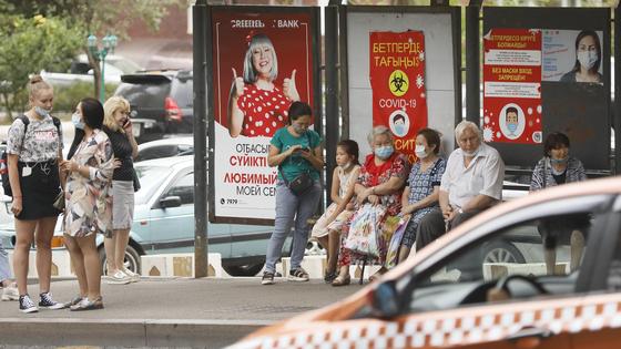 Люди стоят на остановке в Алматы Люди стоят на остановке в Алматы