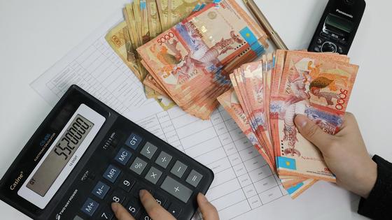 человек считает деньги на калькуляторе человек считает деньги на калькуляторе