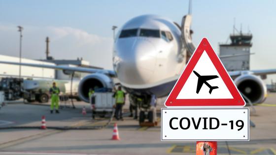 Знак с надписью "COVID-19" на фоне самолета Знак с надписью "COVID-19" на фоне самолета