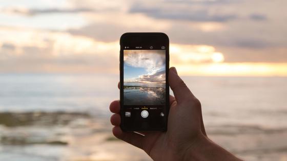 Человек фотографирует закат на смартфон Человек фотографирует закат на смартфон