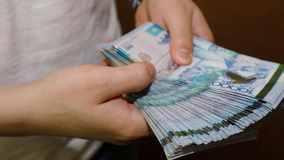 Мужчина держит в руках пачку денег Мужчина держит в руках пачку денег