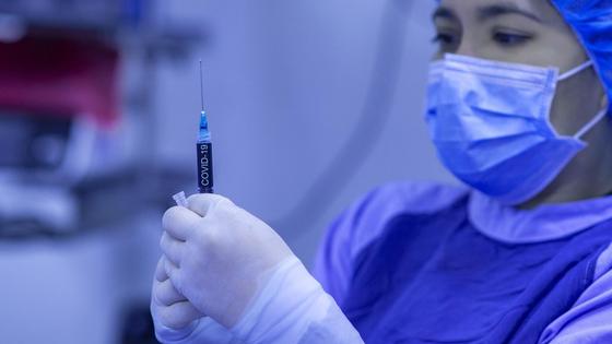 Врач держит в руках шприц с лекарством Врач держит в руках шприц с лекарством