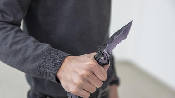 Мужчина держит нож в руке Мужчина держит нож в руке