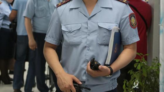 полицейский держит в руках рации полицейский держит в руках рации
