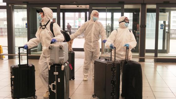 Врачи в защитных костюмах в аэропорту Врачи в защитных костюмах в аэропорту