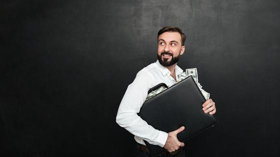 Мужчина держит кейс с деньгами Мужчина держит кейс с деньгами