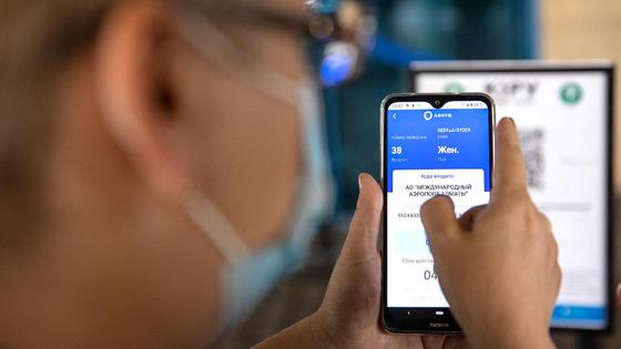 Женщина держит в руках смартфон с открытым приложением Ashyq Женщина держит в руках смартфон с открытым приложением Ashyq