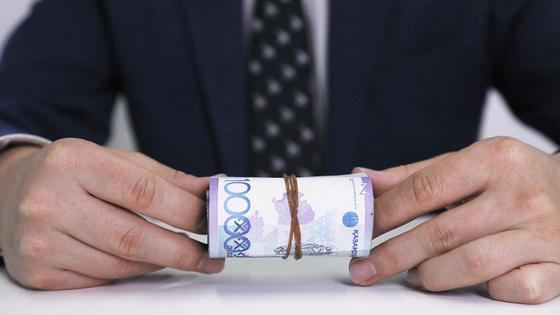 Мужчина держит пачку денег Мужчина держит пачку денег