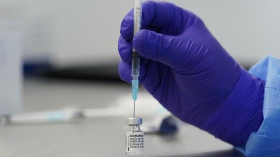 Врач с лаборатории со шприцом в руке Врач с лаборатории со шприцом в руке