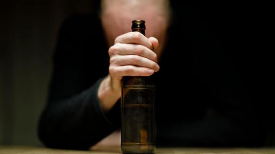 Мужчина держит в руке бутылку Мужчина держит в руке бутылку