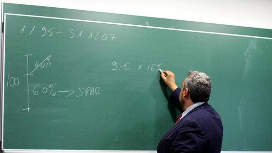 Преподаватель чертит мелом на доске Преподаватель чертит мелом на доске