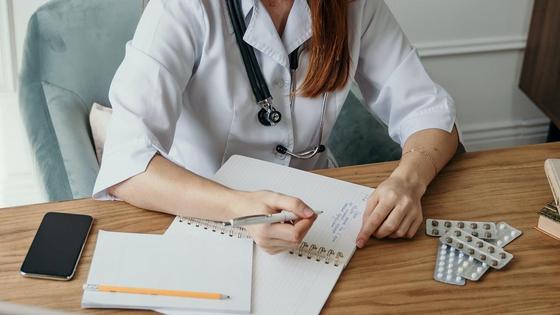 Врач сидит за столом в больнице Врач сидит за столом в больнице