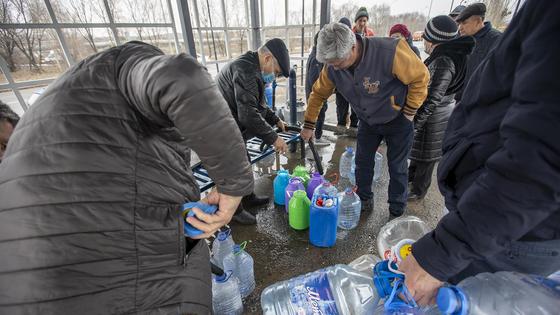 Люди набирают воду возле колонки Люди набирают воду возле колонки