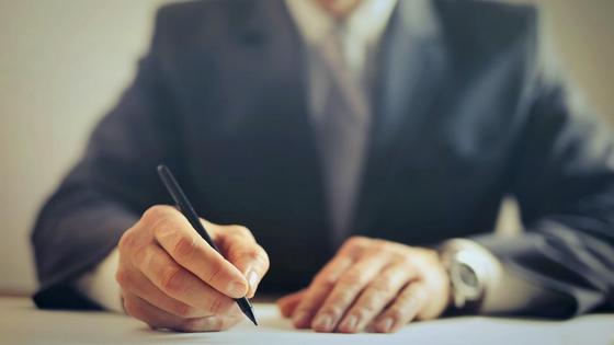 мужчина подписывает документ мужчина подписывает документ