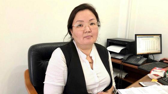 Жанар Мадеева сидит за столом Жанар Мадеева сидит за столом