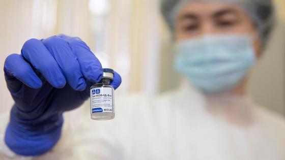 Медработница держит в руке ампулу с вакциной Медработница держит в руке ампулу с вакциной