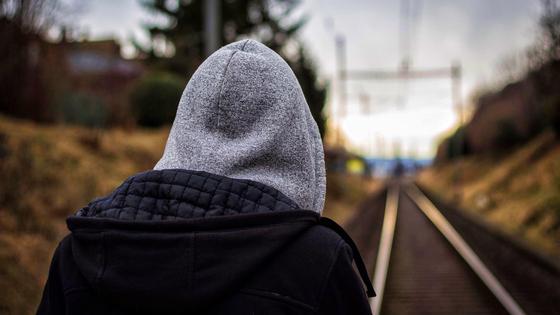 Мальчик стоит на железнодорожных путях Мальчик стоит на железнодорожных путях