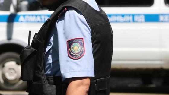 Полицейский в форме стоит возле служебного автомобиля Полицейский в форме стоит возле служебного автомобиля