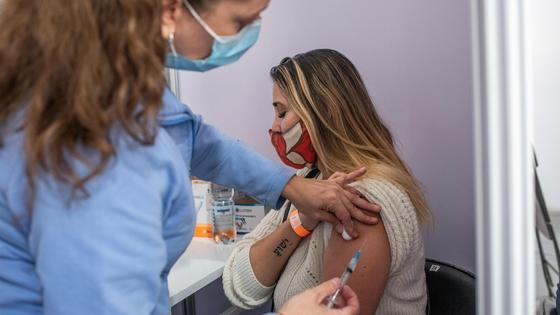 Врач вводит вакцину женщине Врач вводит вакцину женщине