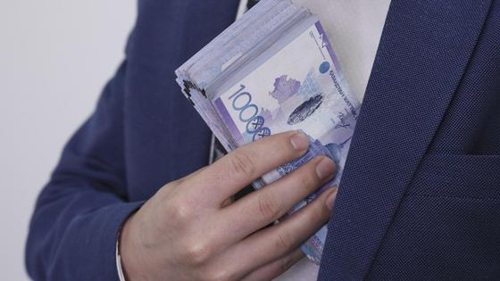 мужчина кладет пачку денег в карман пиджака мужчина кладет пачку денег в карман пиджака