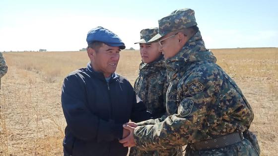Пропавший парень и военнослужащие Нацгвардии стоят в поле Пропавший парень и военнослужащие Нацгвардии стоят в поле