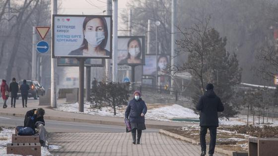 Женщина в маске идет по улице Женщина в маске идет по улице