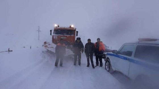Полицейские стоят на заснеженной трассе Полицейские стоят на заснеженной трассе