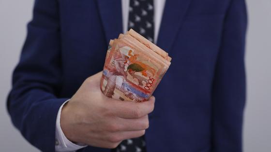 Мужчина держит пачку денег в руке Мужчина держит пачку денег в руке