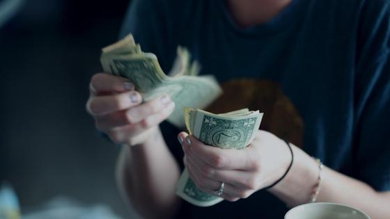 Женщина пересчитывает доллары Женщина пересчитывает доллары