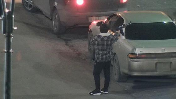 Молодой человек поднимает руку с игрушечным автоматом Молодой человек поднимает руку с игрушечным автоматом