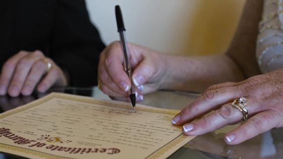 Женщина подписывает свидетельство о браке Женщина подписывает свидетельство о браке