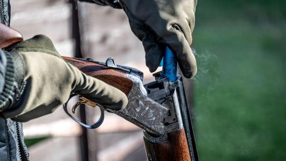 Мужчина закладывает патрон в охотничье ружье Мужчина закладывает патрон в охотничье ружье