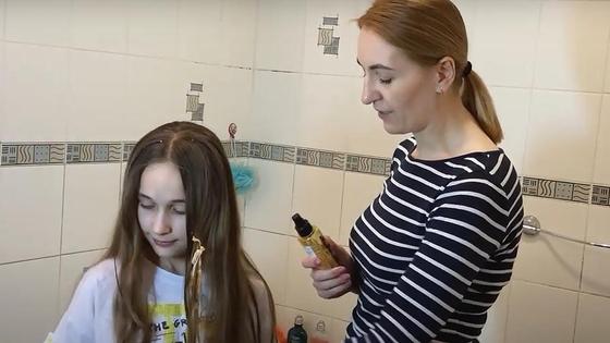 Мама помогает дочери убрать жвачку с волос Мама помогает дочери убрать жвачку с волос