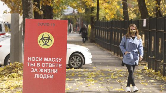 Люди в масках идут по улице Люди в масках идут по улице
