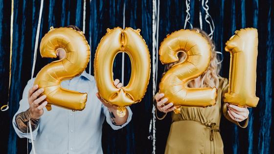 Мужчина и женщина держат в руках цифры 2021 Мужчина и женщина держат в руках цифры 2021