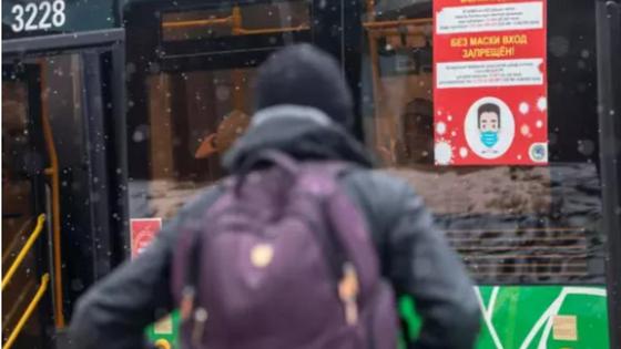Сөмкесі бар жігіт автобус қасында тұр Сөмкесі бар жігіт автобус қасында тұр