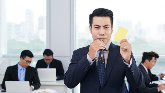 Мужчина показывает желтую карточку Мужчина показывает желтую карточку