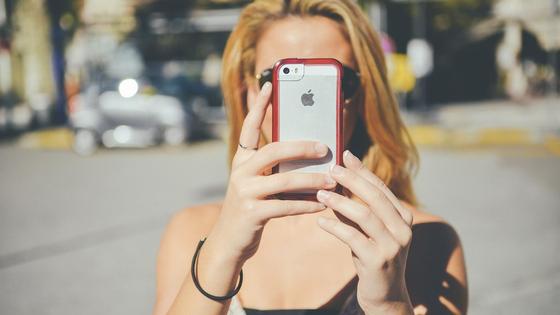 девушка держит в руках смартфон девушка держит в руках смартфон