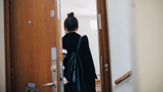 Женщина в черной одежде заходит в помещение Женщина в черной одежде заходит в помещение