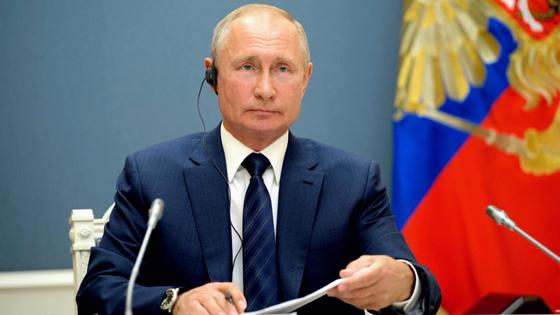 Владимир Путин сидит за столом Владимир Путин сидит за столом