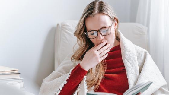 Уставшая девушка в очках читает книгу Уставшая девушка в очках читает книгу