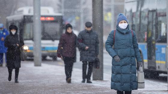 Люди в масках идут по улице Люди в масках идут по улице