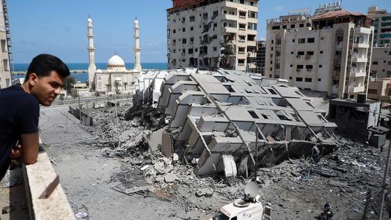 Человек смотри на разрушенное здание в секторе Газа Человек смотри на разрушенное здание в секторе Газа