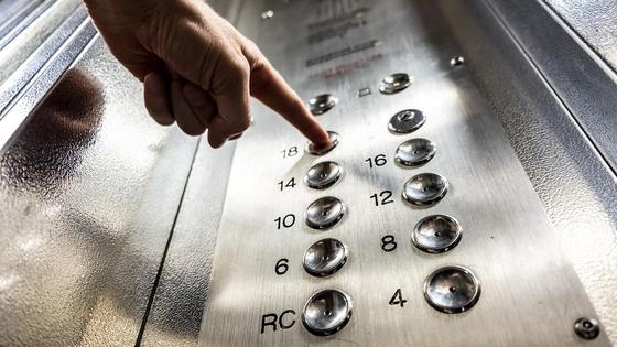 Мужчина нажал на кнопку в лифте Мужчина нажал на кнопку в лифте