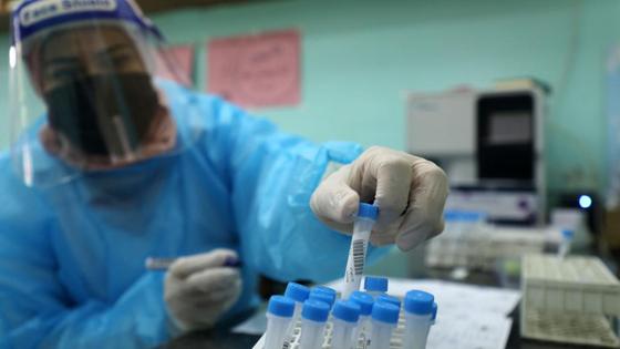 Медработница трогает рукой пробирку Медработница трогает рукой пробирку