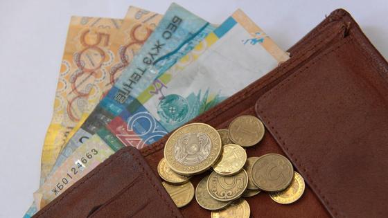 В кошельке лежат купюры и монеты тенге В кошельке лежат купюры и монеты тенге