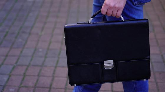 Мужчина несет портфель Мужчина несет портфель